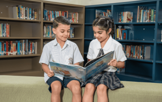 A photo of two St Michael's Catholic Primary School Belfield students reading in the library and on their journey to 2025 NAPLAN results success