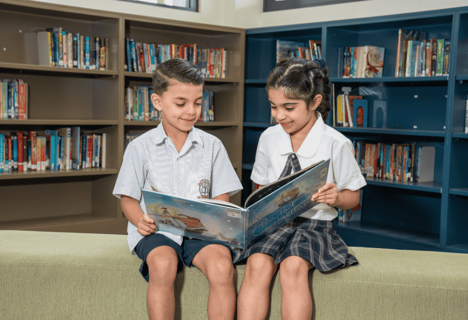 A photo of two St Michael's Catholic Primary School Belfield students reading in the library and on their journey to 2025 NAPLAN results success